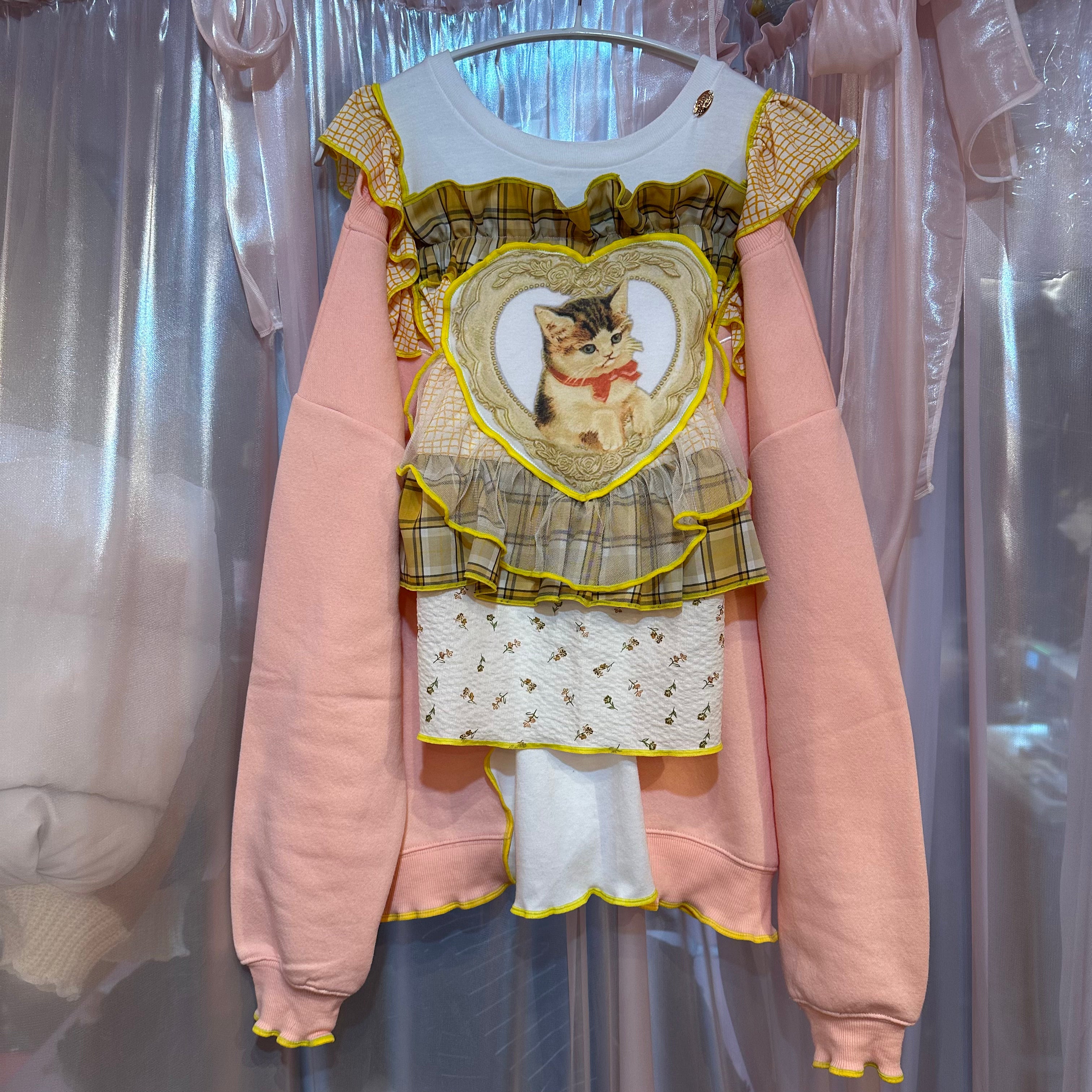 黄色のチェック柄とピンクの猫柄のスウェットシャツ